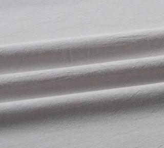 Handmade light grey cotton tablecloth with soft texture and elegant drape, styled for a modern, minimalist dining setting.