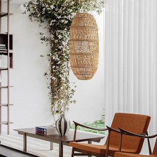 Woven rattan pendant light with warm texture styled in a modern living room.