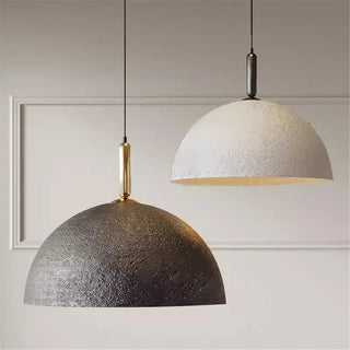 Black and white dome pendant lights with warm glow, minimalist design, suspended from ceiling.