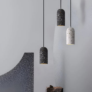 Three modern pendant lights with speckled design in a minimalist interior.