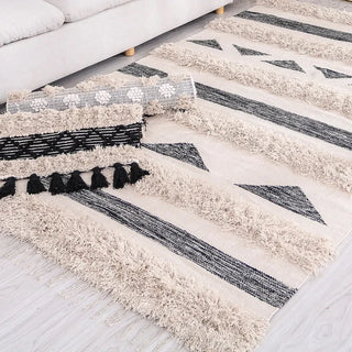 Handwoven Moroccan cotton kilim rug with tufted construction, ivory and black geometric design, and tactile fringe – perfect for Scandi, Boho, or minimalist interiors.