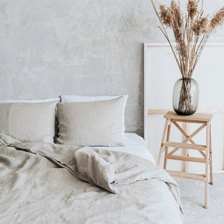 Natural linen bedding set with zip closure, styled on a bed with two pillows and a cozy duvet, creating a calm, minimalist bedroom look.