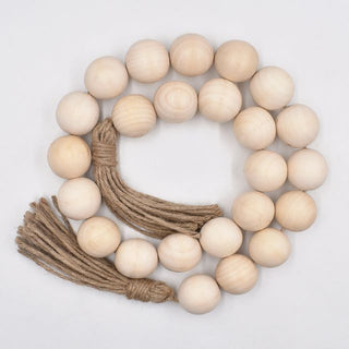 A nature-inspired oversized Wooden Bead Garland, handcrafted from natural wood and finished with bold hemp tassels. This rustic, boho décor piece adds relaxed charm to any interior, perfect for styling on trays, plant pots, candle holders, or hanging on walls and doors for a chic, earthy touch.