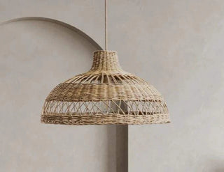 Natural Tama handwoven wicker pendant light with curved crisscross rattan weave, creating soft ambient lighting for modern and coastal interiors.