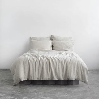 Natural linen pillows and duvet cover with coconut buttons, styled in a minimalist, scandi bedroom.