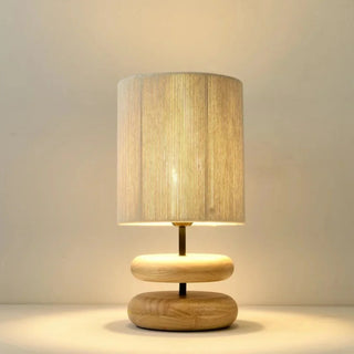 Yuni oak table lamp with smooth wooden base and handwoven fabric shade, minimalist lighting for bedside, console, or living spaces.