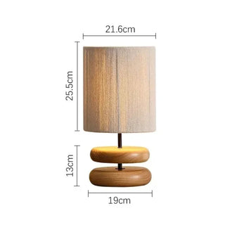 Yuni oak table lamp with smooth wooden base and handwoven fabric shade, minimalist lighting for bedside, console, or living spaces.