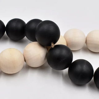 Oversized Wooden Bead Garlands, handcrafted from natural wood with a black or natural coating and bold hemp tassels. This rustic, boho décor piece adds relaxed charm to any interior, perfect for styling on trays, plant pots, candle holders, or hanging on walls and doors for a chic, earthy touch.