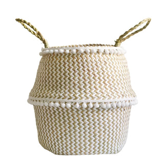 Handwoven natural and white seagrass storage basket with handles, perfect as a stylish hanging basket, pot planter, or decorative storage solution. This eco-friendly, two-tone basket adorned with charming pom poms adds a touch of natural boho touch while keeping your space organized. Shop handcrafted storage baskets at our natural homeware store.