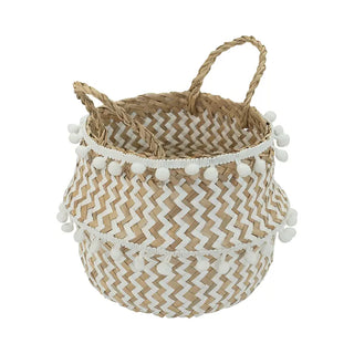 Handwoven natural and white seagrass storage basket with handles, perfect as a stylish hanging basket, pot planter, or decorative storage solution. This eco-friendly, two-tone basket adorned with charming pom poms adds a touch of natural boho touch while keeping your space organized. Shop handcrafted storage baskets at our natural homeware store.