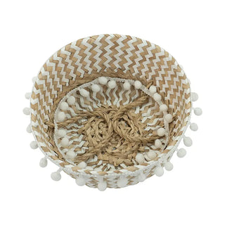 Handwoven natural and white seagrass storage basket with handles, perfect as a stylish hanging basket, pot planter, or decorative storage solution. This eco-friendly, two-tone basket adorned with charming pom poms adds a touch of natural boho touch while keeping your space organized. Shop handcrafted storage baskets at our natural homeware store.