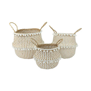 Handwoven natural and white seagrass storage basket with handles, perfect as a stylish hanging basket, pot planter, or decorative storage solution. This eco-friendly, two-tone basket adorned with charming pom poms adds a touch of natural boho touch while keeping your space organized. Shop handcrafted storage baskets at our natural homeware store.