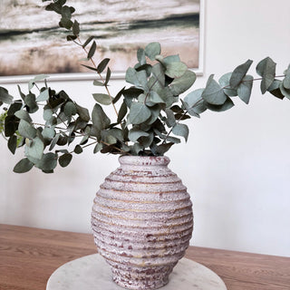 Handcrafted ribbed ceramic vase with antique white wash and urn-like silhouette displayed with eucalyptus stems. A timeless decorative piece for rustic, wabi-sabi, or minimalist interiors.