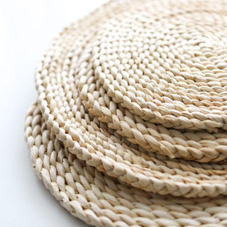 Natural round handwoven corn husk placemats and coasters, eco-friendly and heat-resistant for stylish table protection.