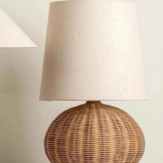 Woven wicker table lamp creating warm ambient light