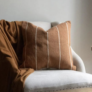 Earthy striped cushion styled for natural and modern interiors.