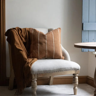 Textured terracotta cushion with gentle cream stripes for sofa, chair or bed styling.