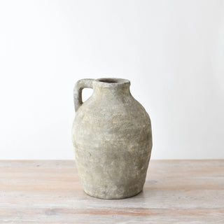 Rustic terracotta jug shaped vase with a matte texture and loop handle.