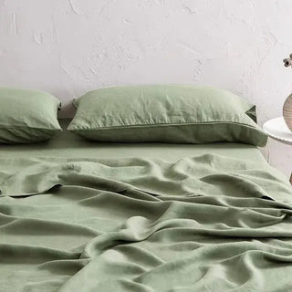 Sage green linen flat sheet and pillowcases set styled on a minimalist bed - perfect for modern, boho and scandi bedrooms. 