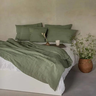 Sage green linen flat sheet and pillowcases set styled on a minimalist bed - perfect for modern, boho and scandi bedrooms. 