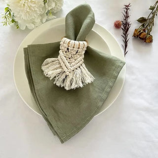 Sage green linen napkin with soft texture and natural drape, styled with a boho macrame napkin ring.