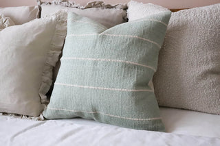 Layered cushion styling in modern bedrooms.