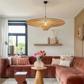 Woven rattan ceiling pendant with flowing organic form and warm ambient lighting featured in a contemporary living room.