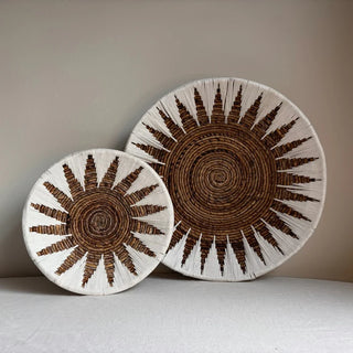 Two round wall basket set in white and natural brown with a sun-inspired woven pattern