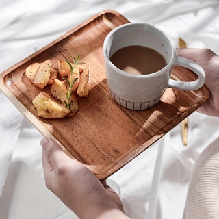 Handcrafted acacia wood square serving tray with a smooth, hand-rubbed finish. Perfect for serving bread, pastries, or breakfast in style. This natural home decor piece blends functionality with rustic charm, making it an ideal addition to any kitchen or dining space. Shop artisanal wooden serveware at our natural homeware store