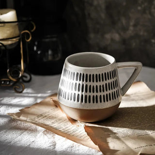 Nordic-inspired handmade clay mug with a white satin-speckled glaze and black graphic motif, perfect for tea and coffee.