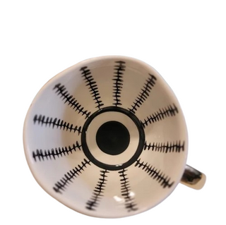 Handmade ceramic cup with black and white geometric design and a gold handle, minimalist and artistic in style.
