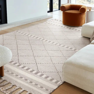 Handwoven taupe and white wool rug with geometric kilim pattern and braided fringe for modern, boho and nordic interiors.