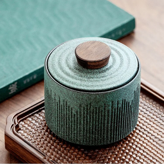 Elegant ceramic tea caddy with a dark walnut lid, perfect for kitchen or home organization. Featuring a textured, artisanal design in a turquoise hue, this airtight container is ideal for storing tea, coffee, spices, or small household items. A stylish and functional kitchen addition to a contemporary, minimalist or Japanese aesthetic.