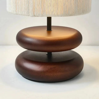 Yuni walnut table lamp with smooth wooden base and handwoven fabric shade, minimalist lighting for bedside, console, or living spaces.