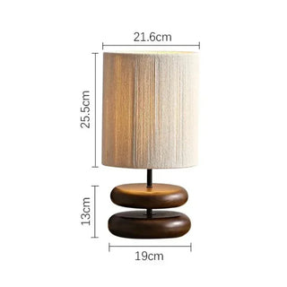 Yuni walnut table lamp with smooth wooden base and handwoven fabric shade, minimalist lighting for bedside, console, or living spaces.