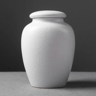 Elegant white ceramic large storage jars in various shapes and sizes, featuring a soft textured finish and airtight lids. Perfect for storing tea, coffee, sugar, and spices while adding a modern, sophisticated touch to any kitchen countertop.