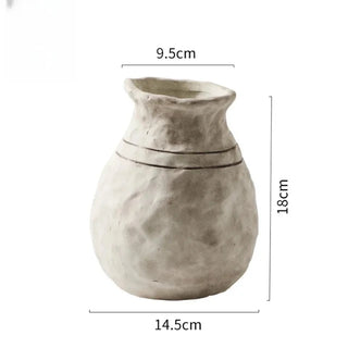 The Alma Clay Vase, made from pale stoneware clay, adds rustic charm with its textured finish and organic shape. Featuring uneven edges for a beautifully raw, simple design, this decorative accessory is perfect for displaying flower or branch arrangements. The Alma flower vase makes an elegant addition to shelves or consoles, enhancing natural home décor.