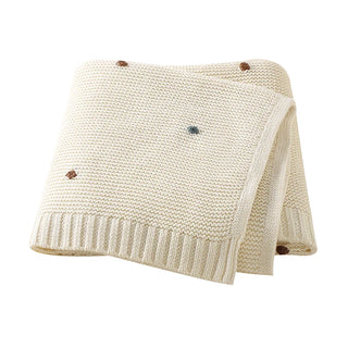 Bibi Cotton Knit Baby Blanket in soft white, folded neatly.