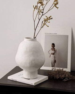 White ceramic sculptural vase with a minimalist design, available in two sizes that can be styled together. The vase features a creative, artistic shape and a sleek black finish, perfect for adding a bold, statement look to any modern or contemporary interior.