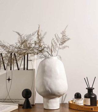 White ceramic sculptural vase with a minimalist design, available in two sizes that can be styled together. The vase features a creative, artistic shape and a sleek black finish, perfect for adding a bold, statement look to any modern or contemporary interior.