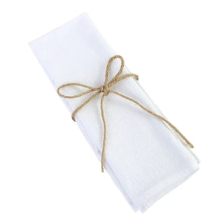 Set of four handmade white cotton table napkins with soft texture and minimalist design, styled for a modern table setting.