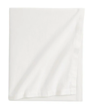 Handmade white cotton tablecloth with soft texture and elegant drape, styled for a modern, minimalist dining setting.