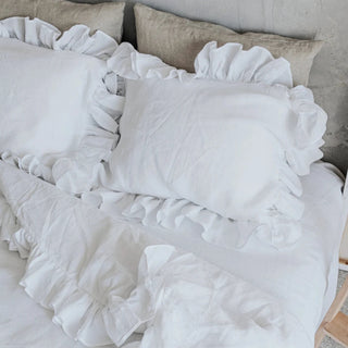 White ruffled linen standard pillowcase styled with matching duvet and sheets on a modern, minimalist bed for a clean, airy look.