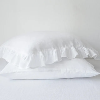 Natural ruffled linen square pillowcase in white, made from 100% flax linen, styled on a soft neutral bed – available in multiple colours and sizes from Arkaim Home.