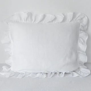 Natural ruffled linen pillowcase in white, made from 100% flax linen, styled on a soft neutral bed – available in multiple colours and sizes from Arkaim Home.