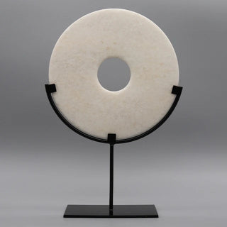 A stunning Marble Disc Ornament carved from elegant white marble, featuring a polished, unique disc displayed on a sleek metal frame. This sophisticated home décor piece adds a touch of luxury to any space, perfect for side tables or consoles. Ideal for creating a stylish focal point, it enhances interiors with its elegant design and timeless appeal. A beautiful addition to modern, minimalist, or contemporary décor.