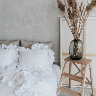 White ruffled linen pillows and duvet cover on a minimalist bed with a neutral background. Perfect linen bedding set for modern, boho or scandi bedrooms.