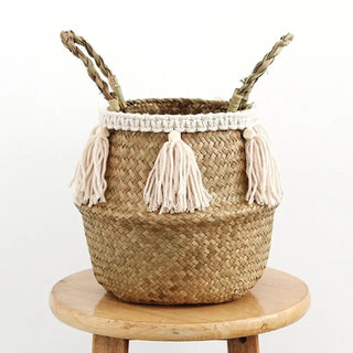 Handwoven natural seagrass storage basket with handles, perfect as a stylish hanging basket, pot planter, or decorative storage solution. This eco-friendly basket, adorned with charming tasselled fringe, adds a natural boho touch while keeping your space organized. Shop handcrafted storage baskets at our natural homeware store.