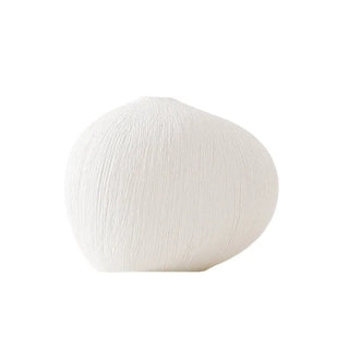 White textured ceramic vase with a minimalist design, available in two colours that can be styled together. The vase features a creative, organic pebble shape and a white matte finish, perfect for adding a bold, statement look to any modern or contemporary interior.