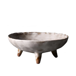 White handmade ceramic raised serving dish with an uneven, textured surface and hand-rubbed glaze. This wabi-sabi inspired decorative fruit bowl adds a natural, organic touch to any home. Perfect as a unique display piece or functional home accessory. Shop artisanal pottery at our natural homeware store.